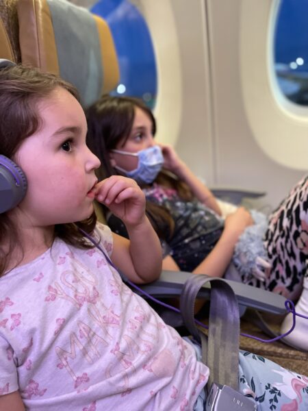 My girls watching films on the flight to New Zealand - Tips for flying long-haul with kids